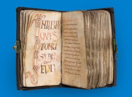 Twee pagina's van een handgeschreven manuscript, rijk versierd