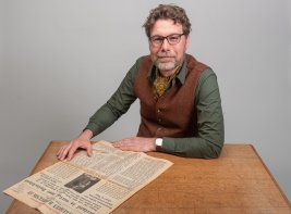 Collectiespecialist Huib met een krant