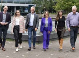 Directieteam van de KB loopt buiten het gebouw naar de camera toe