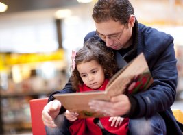 Volwassene die kind voorleest, bij tekst over het project Kwaliteitsimpuls Laagtaalvaardige Ouders.