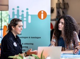 Een bibliotheekmedewerker helpt een klant.