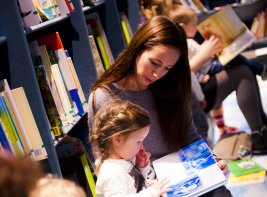 Volwassenen lezen kinderen voor in de bibliotheek