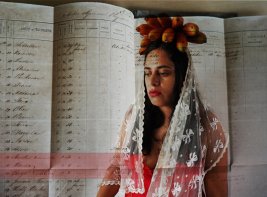 Beeld gemaakt door Sarojini Lewis, kunstenaar en onderzoeker. Zichtbaar is een vrouw voor een handgeschreven document.