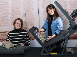 KB-medewerkers Annelynn en Janou met apparatuur om een middeleeuws handschrift te digitaliseren.