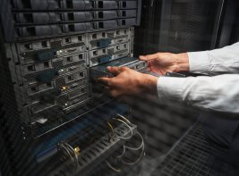 Handen trekken iets uit een kast van een serverruimte