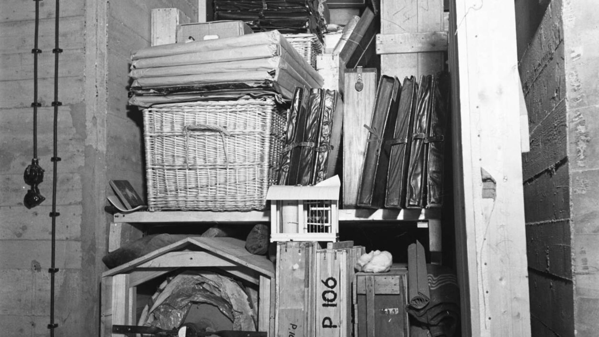 Diverse kunstobjecten tijdens de oorlog opgeslagen in een houten kist in een depot. Met linksonder opgerold, het fameuze schilderij De Nachtwacht van Rembrandt. Dagelijks werd de rol gedraaid om de druk op het kwetsbare schilderwerk te verdelen. Foto: Nationaal Archief. 