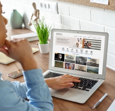 Een vrouw bekijkt op een laptop de homepage van Literatuurgeschiedenis.org.