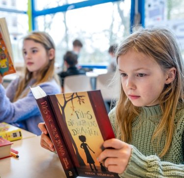 Twee kinderen die een boek lezen op school