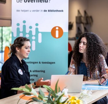 Een bibliotheekmedewerker helpt een klant.