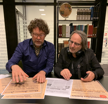 Paul en Huib bekijken kranten