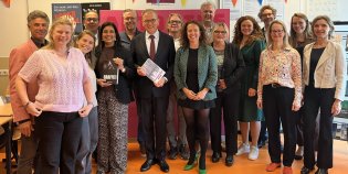 Minister Eppo Bruins en Staatssecretaris Mariëlle Paul in het midden van een groep mensen.