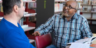 twee mannen in gesprek aan boekentafel