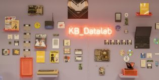 Een muur met oude computerapparatuur en het logo van het KB_Datalab