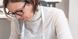 Boekrestaurator Imke Neels werkt aan een leren boekband