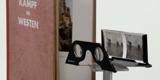 Een opengeslagen boek en twee stereoscopische foto's met de bijbehorende bril