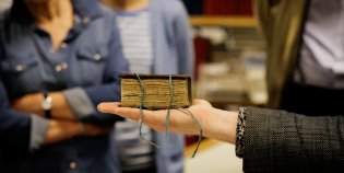 Een klein boekje op een handpalm