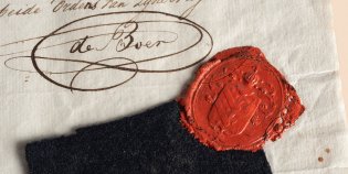 Een zwart lapje stof met een waszegel op een handgeschreven brief