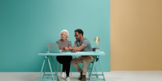 Vrouw en man zitten samen achter een laptop.