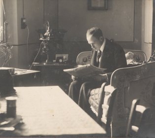 Arius van Tienhoven lezend in zijn kamer.