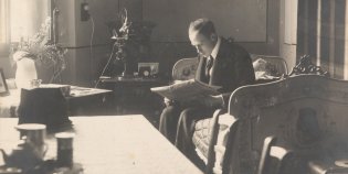 Arius van Tienhoven lezend in zijn kamer.