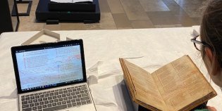 Gruuthusehandschrift naast laptop.