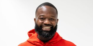 Foto van Jerry Afriyie, hij kijkt in de camera en lacht.