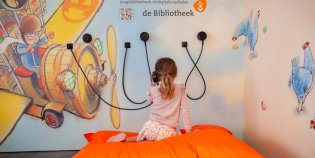 Een meisje luistert naar de jeugdbibliotheek