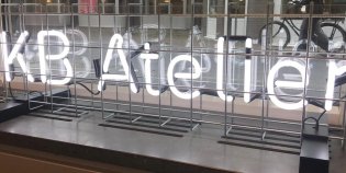 Voor het raam van de KB staan in lichtgevende letters de woorden KB Atelier geschreven.