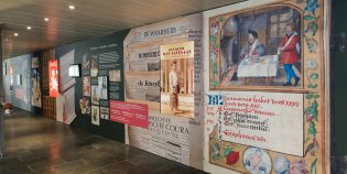 Museumwand in de KB, met onder andere een afbeelding uit een middeleeuws handschrift.