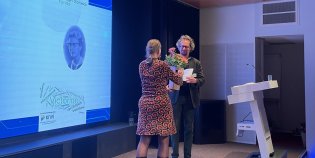 Conservator Steven Claeyssens ontvangt bloemen en een prijs.