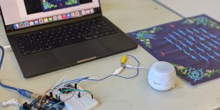 Een handwerk dat met draden is gekoppeld aan een laptop