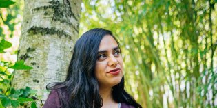 Kunstenaar Sarojini Lewis poseert voor een boom