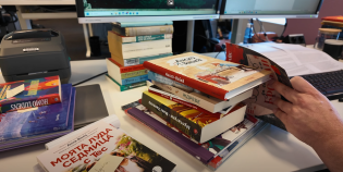 Stapel boeken achter een pc