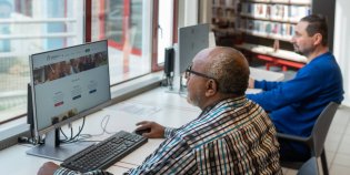 Twee mannen achter computers in een bibliotheek