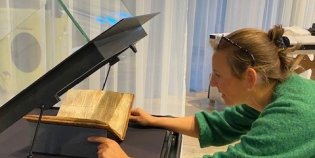 Restaurator legt Gruuthusehandschrift op steun.