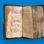 Twee pagina's van een handgeschreven manuscript, rijk versierd