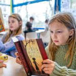 Twee kinderen die een boek lezen op school