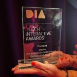 Een foto van een Dutch Interactive Award, een glasplaat met tekst op een voet.