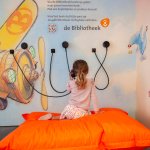 Een meisje luistert naar de jeugdbibliotheek