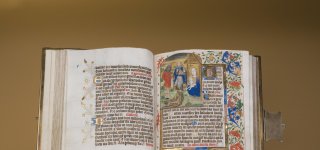 Getijdenboek van de Zwarte-Ogen-meesters opengeklapt bij een miniatuur van de aanbidding van het Christuskind