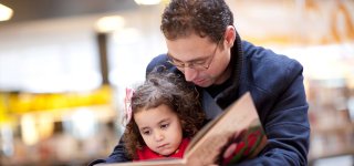 Volwassene die kind voorleest, bij tekst over het project Kwaliteitsimpuls Laagtaalvaardige Ouders.