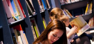 Volwassenen lezen kinderen voor in de bibliotheek