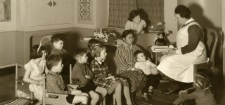 Zuster leest voor aan groep kinderen. Programma Indisch Erfgoed Digitaal.