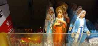 Beeldjes van Maria in een winkelschap.
