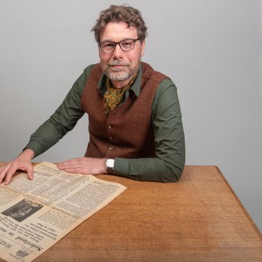 Collectiespecialist Huib met een krant