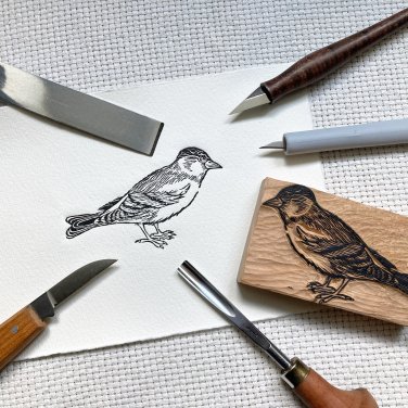Een houtdruk van een vogel, omringd door houtbewerkgereedschap en het houtblok