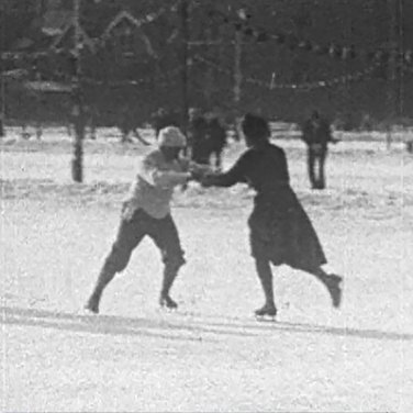 Een screenshot uit een oud filmpje met twee schaatsers
