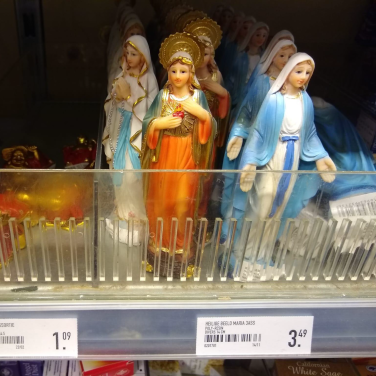 Beeldjes van Maria in een winkelschap.